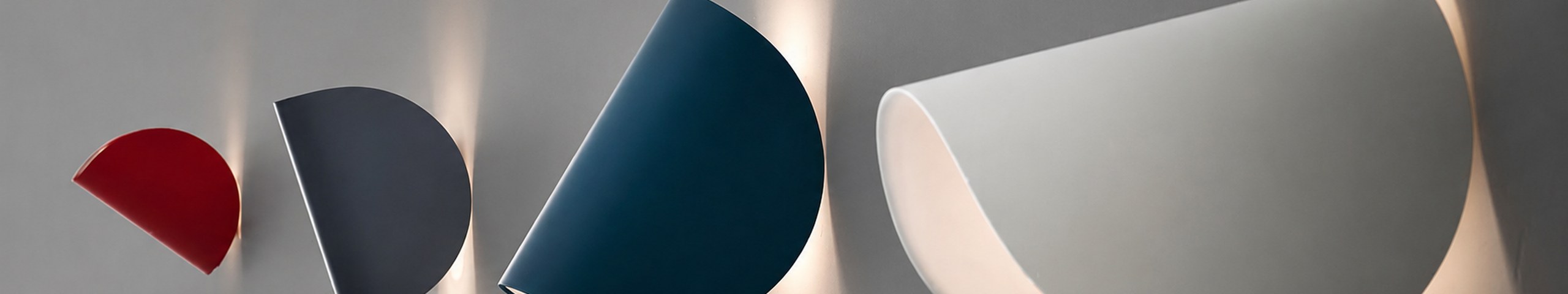 Applique da parete di design in metallo laccato rosso, antracite, blu petrolio e bianco, con luce diffusa sul muro