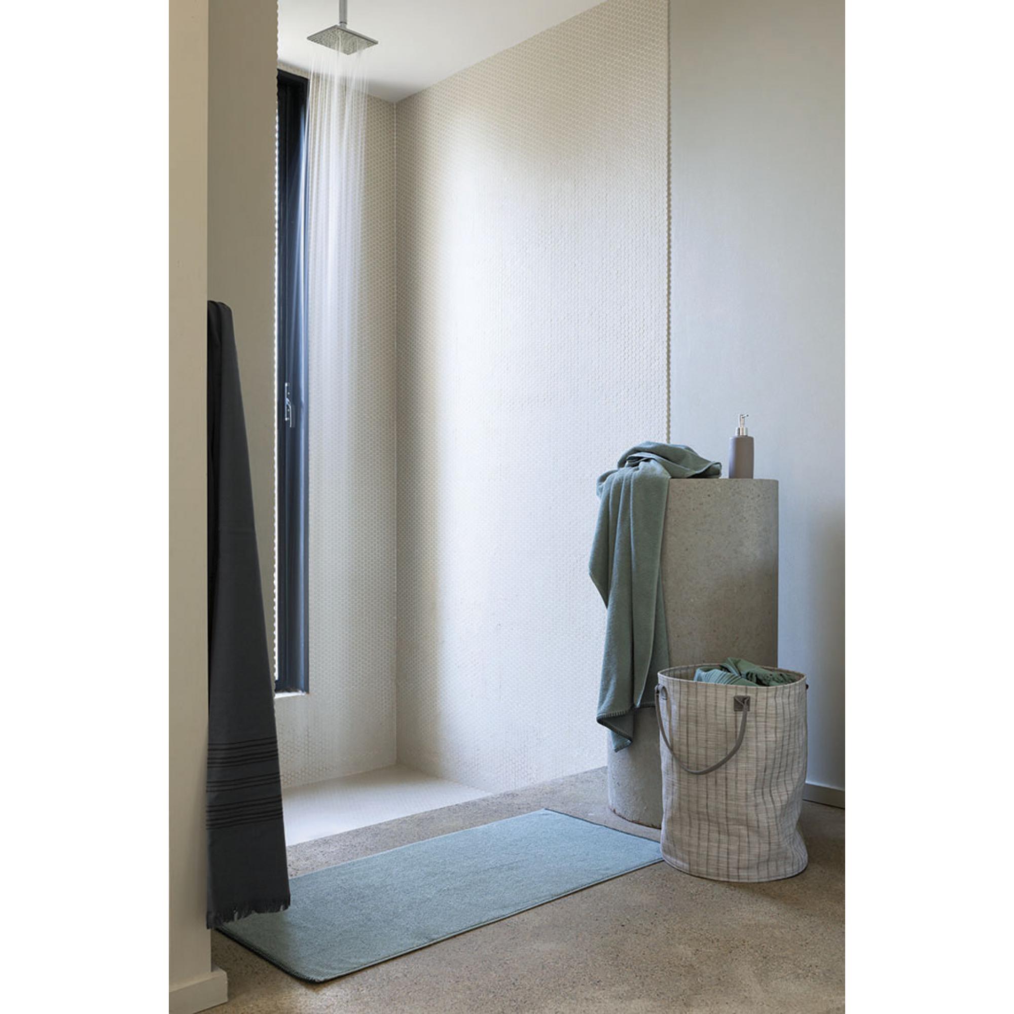Asciugamano Bora color Sauge in un bagno con doccia a pavimento; gli altri oggetti della scena non sono compresi