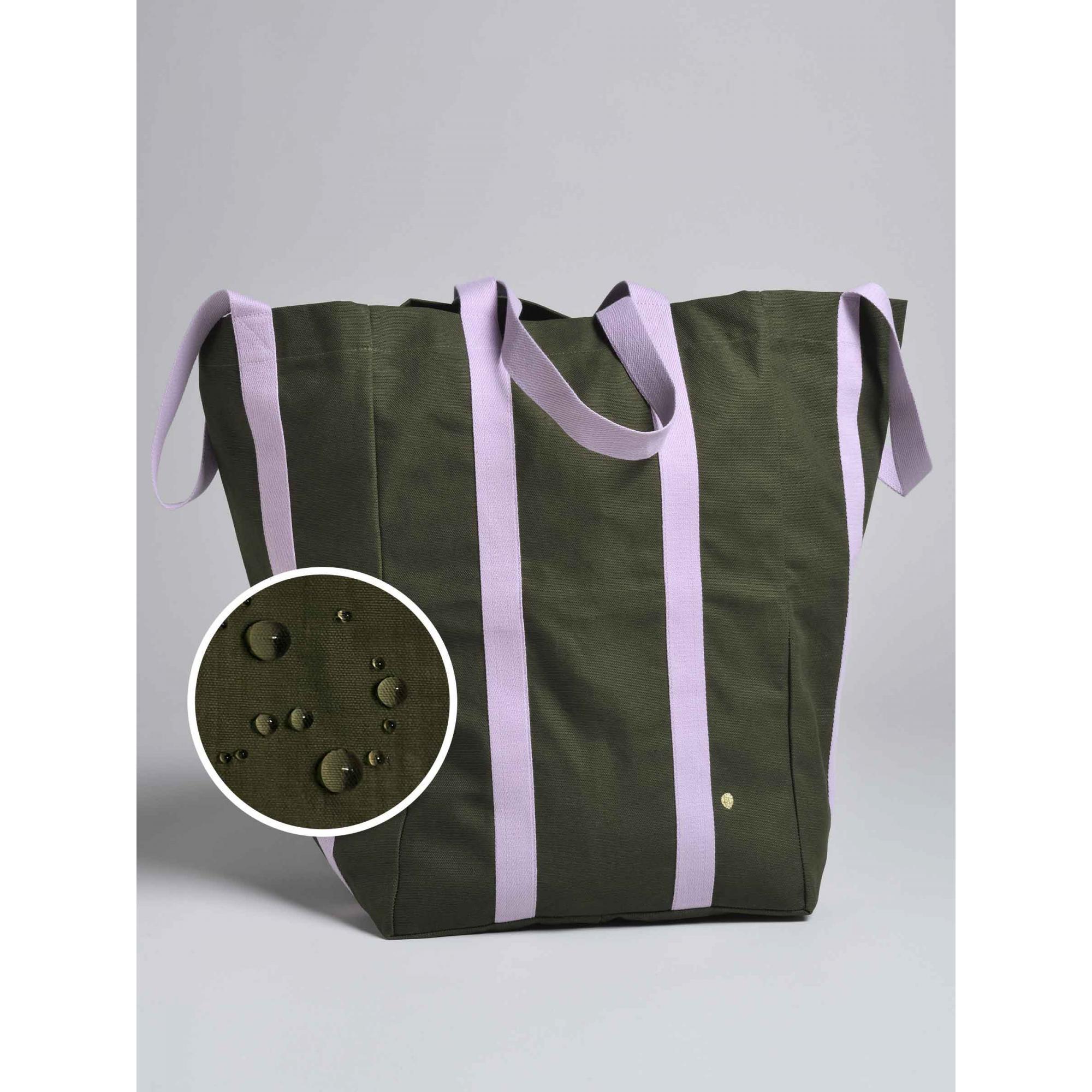 Dettaglio ingrandito della tela di cotone verde oliva della Borsa Maxi Poppins con le gocce d’acqua che restano in superficie senza penetrare: il tessuto è idrorepellente.