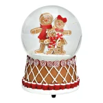 Carillon natalizio su fondo bianco: base marrone decorata a losanghe con bordo rosso e bianco, sormontata da una sfera di vetro con la neve e due figure di omini di pan di zenzero abbracciati.
