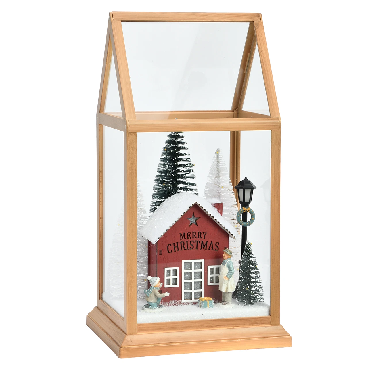 Lanterna natalizia verticale a serra con struttura in plastica color legno chiaro, a luci spente, su fondo bianco: una casetta rossa con la scritta Merry Christmas sul fronte, abeti innevati e un lampione.