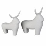 I due tori decorativi Tauro in ceramica sabbiata bianca, fotografati di profilo su fondo bianco: a sinistra il toro piccolo, 17 × 14 × 18 cm, a destra il toro grande, 20 × 15 × 23 cm. Corpo pieno e squadrato, zampe tronche, collo con la gobba e corna sottili piegate all'indietro; superficie opaca e granulosa, senza dettagli incisi. Il set comprende entrambi i pezzi.