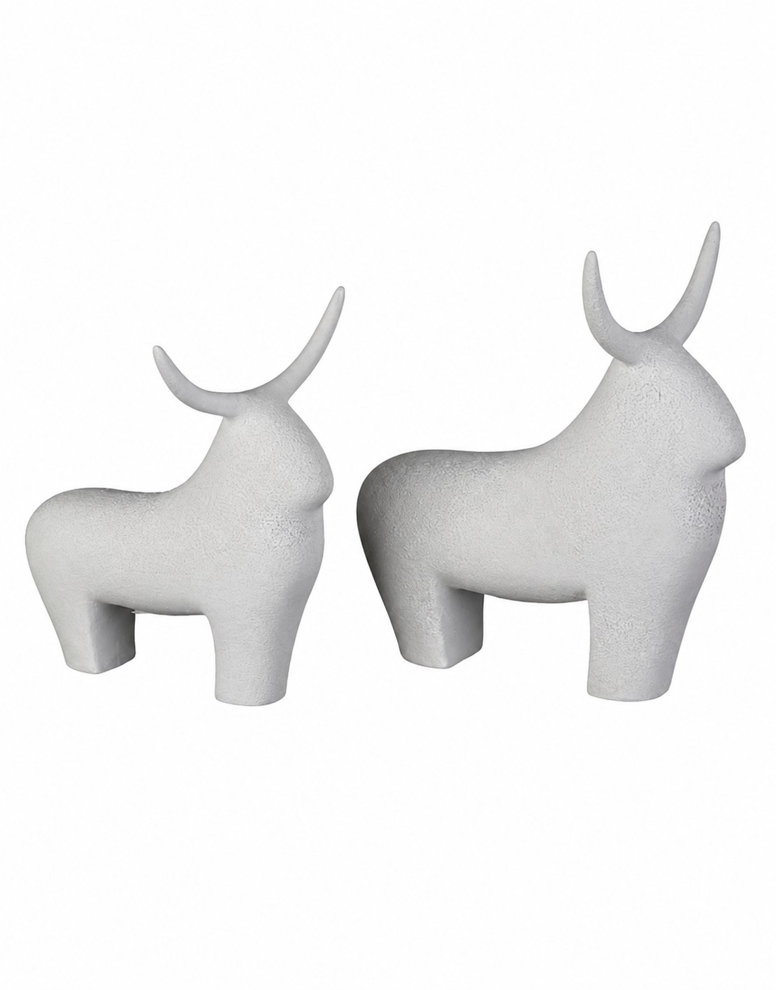 I due tori decorativi Tauro in ceramica sabbiata bianca, fotografati di profilo su fondo bianco: a sinistra il toro piccolo, 17 × 14 × 18 cm, a destra il toro grande, 20 × 15 × 23 cm. Corpo pieno e squadrato, zampe tronche, collo con la gobba e corna sottili piegate all'indietro; superficie opaca e granulosa, senza dettagli incisi. Il set comprende entrambi i pezzi.