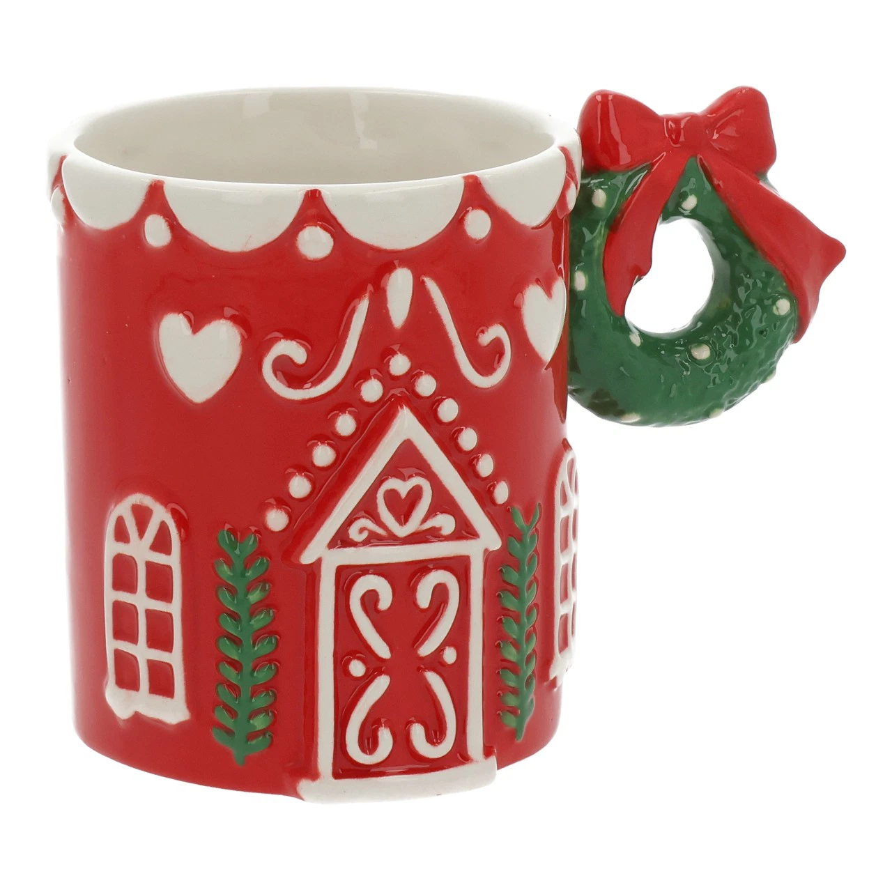 Tazza in ceramica rossa a forma di casetta di Natale, su fondo bianco: porta, finestre e cuori dipinti in bianco, tetto a festoni sul bordo, e manico modellato come una ghirlanda di agrifoglio verde con bacche rosse.