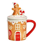 Tazza jumbo in ceramica a forma di casetta di pan di zenzero, su fondo bianco: corpo color biscotto con porta e finestre dipinte in bianco e rosso, manico rosso e coperchio sormontato da un omino di pan di zenzero con un bastoncino di zucchero.