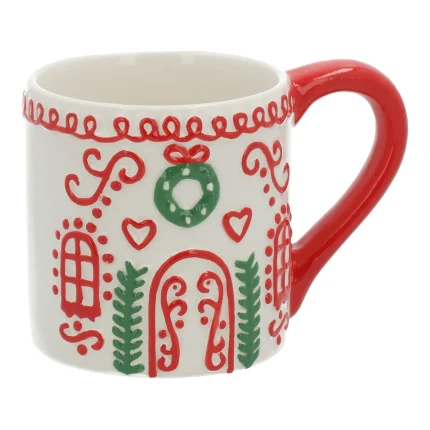 Tazza in ceramica rossa su fondo bianco, con manico rosso: il fronte porta archi, cuori, rametti verdi e una ghirlanda dipinti in bianco e verde, e un festone di glassa bianca corre lungo il bordo superiore.