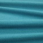 Tessuto Linara di Romo nella colorazione Kingfisher drappeggiato, per mostrarne la caduta e la finitura spazzolata.