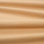 Tessuto Linara di Romo nella colorazione Beeswax drappeggiato, per mostrarne la caduta e la finitura spazzolata.