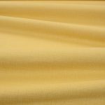 Tessuto Linara di Romo nella colorazione Turmeric drappeggiato, per mostrarne la caduta e la finitura spazzolata.