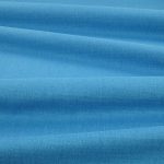 Tessuto Linara di Romo nella colorazione Persian Blue drappeggiato, per mostrarne la caduta e la finitura spazzolata.