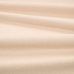 Tessuto Linara di Romo nella colorazione Latte drappeggiato, per mostrarne la caduta e la finitura spazzolata.
