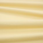 Tessuto Linara di Romo nella colorazione Butternut drappeggiato, per mostrarne la caduta e la finitura spazzolata.