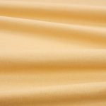 Tessuto Linara di Romo nella colorazione Amber drappeggiato, per mostrarne la caduta e la finitura spazzolata.