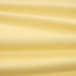 Tessuto Linara di Romo nella colorazione Jonquil drappeggiato, per mostrarne la caduta e la finitura spazzolata.