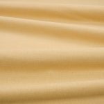 Tessuto Linara di Romo nella colorazione Nectar drappeggiato, per mostrarne la caduta e la finitura spazzolata.