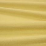 Tessuto Linara di Romo nella colorazione Dandelion drappeggiato, per mostrarne la caduta e la finitura spazzolata.