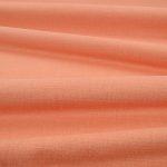 Tessuto Linara di Romo nella colorazione Papaya drappeggiato, per mostrarne la caduta e la finitura spazzolata.