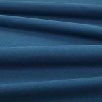 Tessuto Linara di Romo nella colorazione Venetian Blue drappeggiato, per mostrarne la caduta e la finitura spazzolata.