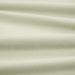 Tessuto Linara di Romo nella colorazione Soft Jade drappeggiato, per mostrarne la caduta e la finitura spazzolata.
