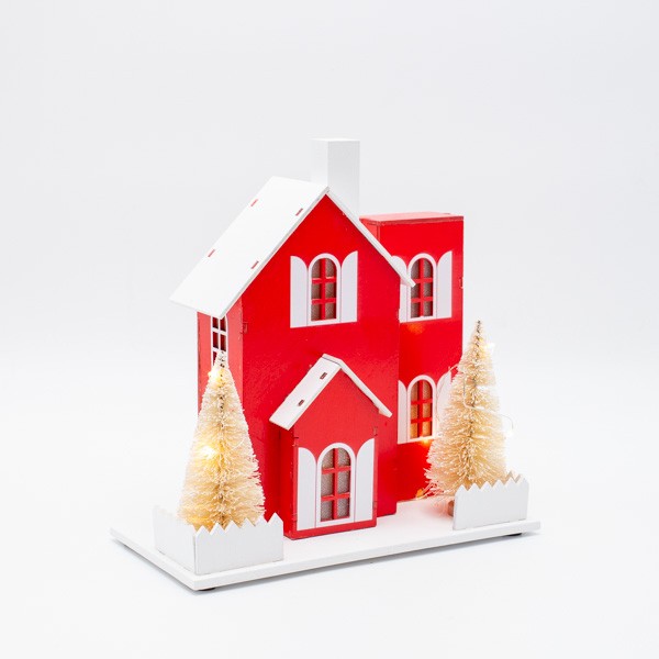 Casetta di Natale luminosa in legno rossa e bianca, fotografia su fondo bianco
