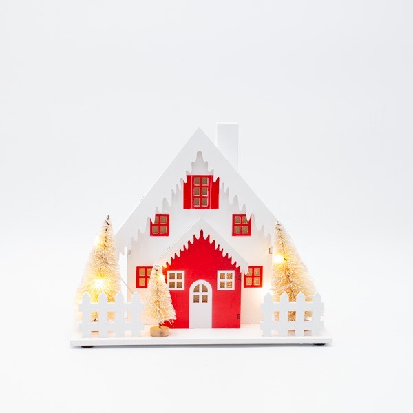 Casetta di Natale luminosa in legno con alberi e tetto innevato, fotografia su fondo bianco