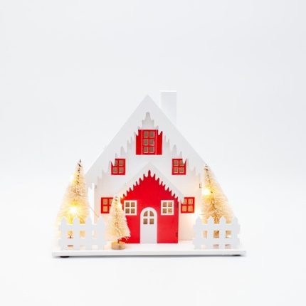 Casetta di Natale luminosa in legno con alberi e tetto innevato, fotografia su fondo bianco