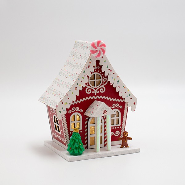 Casetta di Natale luminosa in carta rossa con biscotto di pan di zenzero, fotografia del produttore: gli altri oggetti eventualmente presenti nella scena non sono compresi
