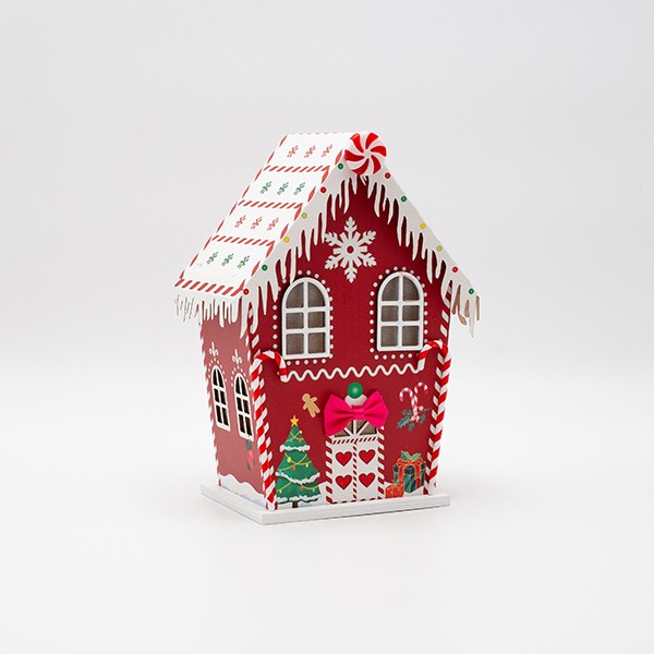 Casetta di Natale luminosa in carta rossa con caramelle, fotografia del produttore: gli altri oggetti eventualmente presenti nella scena non sono compresi