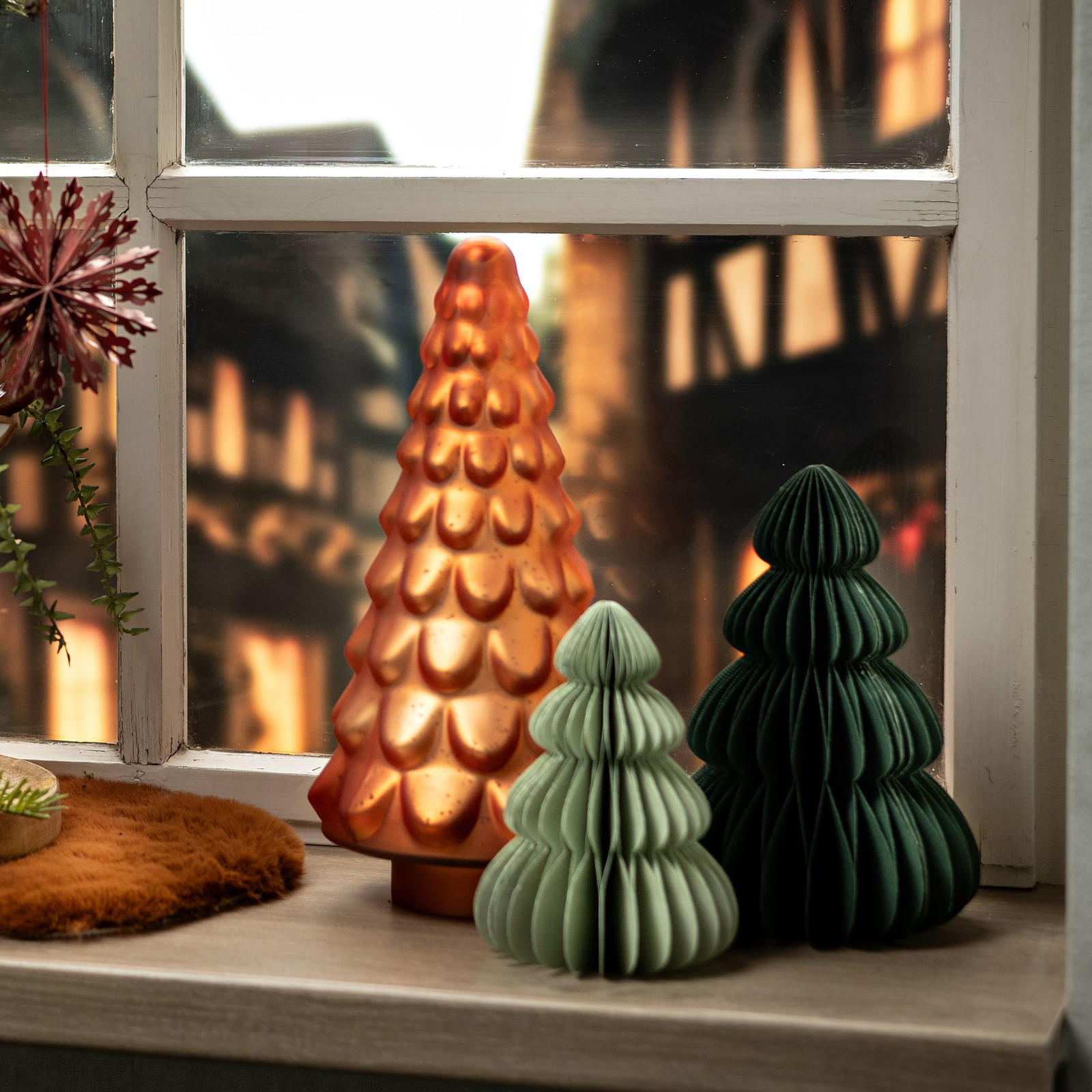 Albero di Natale honeycomb in carta verde abete alto 50 cm in un allestimento natalizio; gli altri oggetti della scena non sono compresi