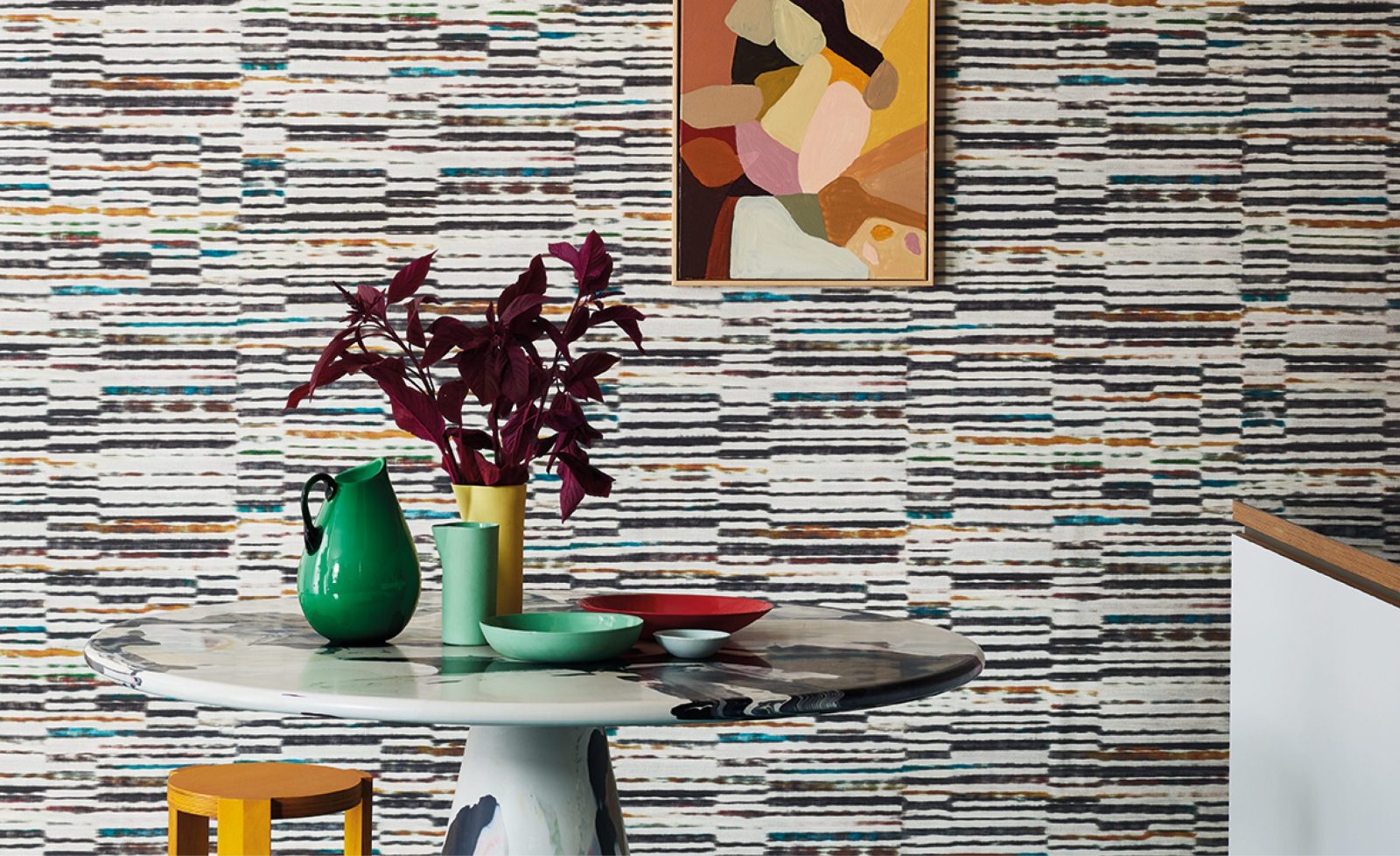 Parete rivestita con la carta da parati Marazzi Amazonia (W928/03): una sala da pranzo con tavolo, vasi, piatti e un quadro appeso. Gli altri oggetti della scena non sono compresi nella vendita.