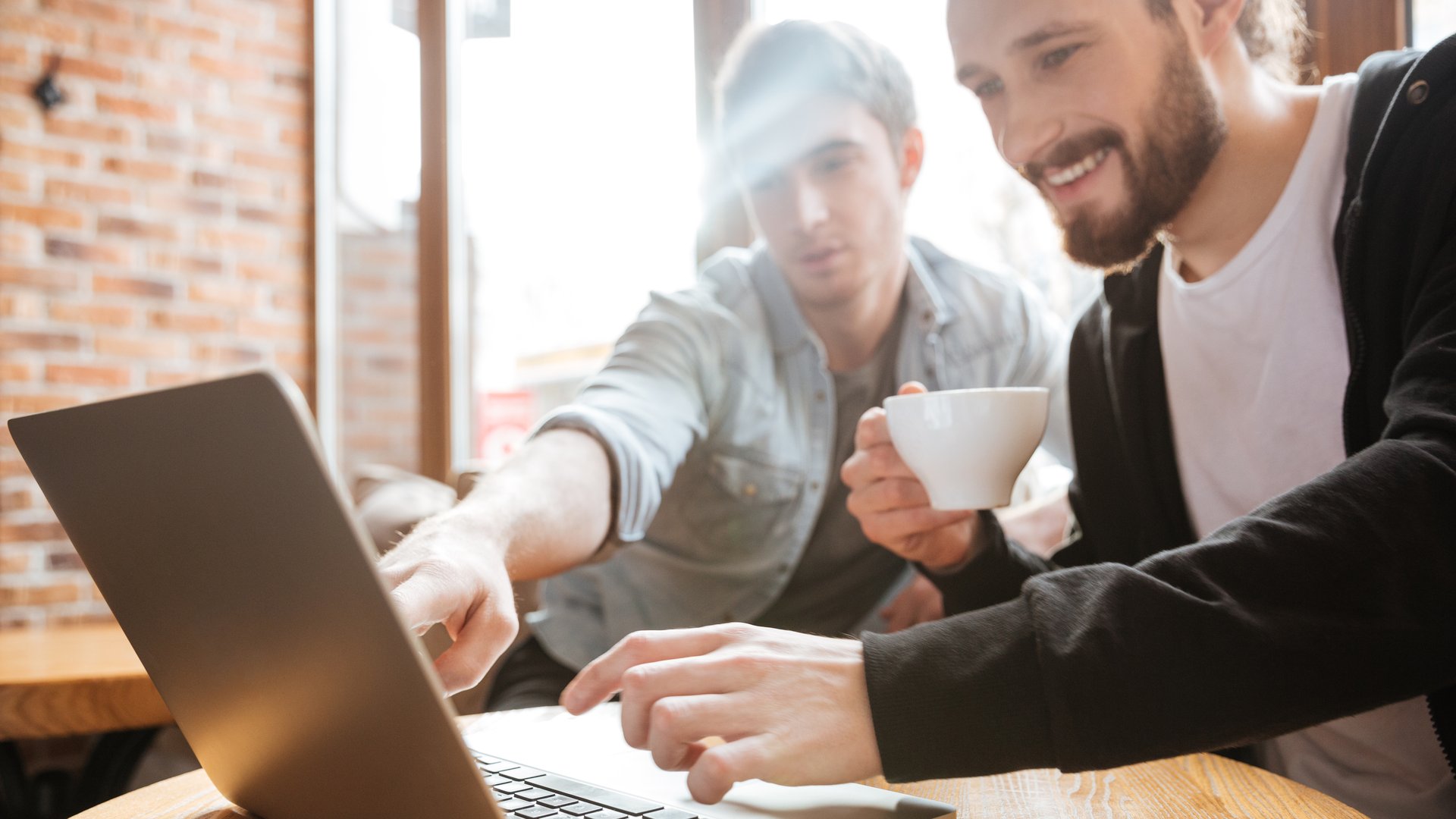 Due persone davanti a un portatile in un caffè: la vetrina online D•VENDOR su D•POT