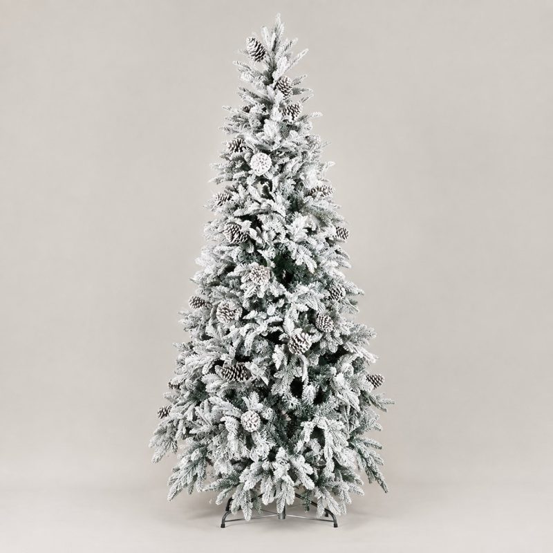 Albero di Natale artificiale Reykjavik alto 210 cm, fittamente innevato di bianco con pigne applicate tra i rami, montato su base a croce in metallo e fotografato su fondo neutro