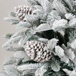 Dettaglio dei rami innevati in polietilene e PVC dell’albero di Natale Reykjavik 210 cm, con le pigne applicate tra gli aghi