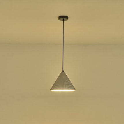 Lampada a sospensione Platre in cemento grigio plissettato, diametro 24 cm, accesa contro una parete chiara. La lampadina non è compresa