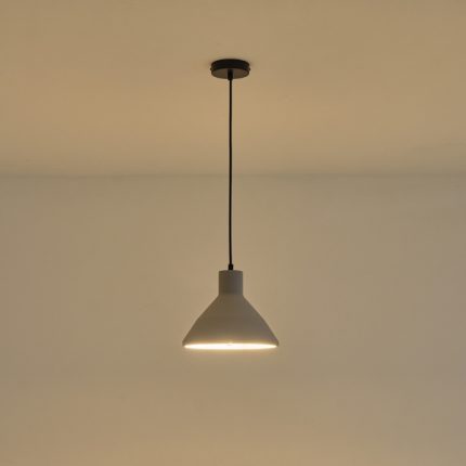 Lampada a sospensione Yeso in cemento grigio a cono, diametro 24 cm, accesa contro una parete chiara. La lampadina non è compresa