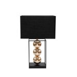 Lampada da tavolo con base e telaio rettangolare in metallo nero, tre sfere dorate impilate al centro e paralume rettangolare nero, su fondo bianco
