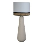 Lampada da tavolo Creta su fondo bianco: base conica in ceramica sabbiata color sabbia, alta 61 cm, e paralume cilindrico bianco di Ø 38 cm con fascia in fibra intrecciata tra due bordini neri; altezza complessiva 94 cm
