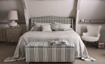 Camera da letto con testiera e cassapanca rivestite nei tessuti a righe della collezione Orton di Romo. In vendita c’è soltanto il tessuto al metro: arredi e complementi della scena non sono compresi.
