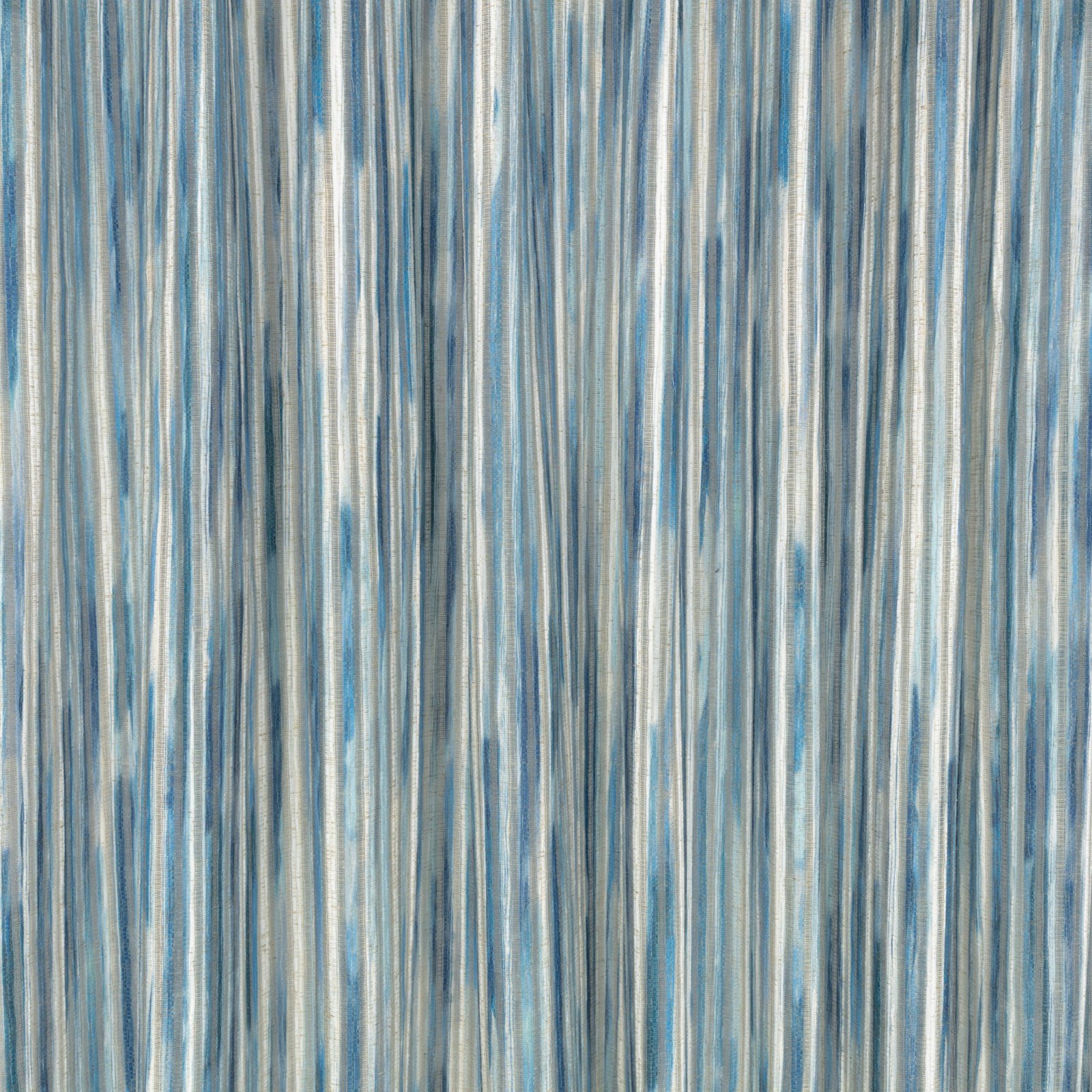 Il velo Rafi di Villa Nova nella colorazione Cerulean drappeggiato in pieghe morbide: righe verticali blu ceruleo, azzurro polvere e grigio ardesia su fondo écru, righe tessute e sovrastampate con velature di colore.