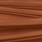 Il velluto Barcelona di Villa Nova nella colorazione Sienna in pieghe morbide, che mostrano la lucentezza del pelo.