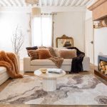 Plaid Betani ruggine sul divano con cuscini in finta pelliccia
